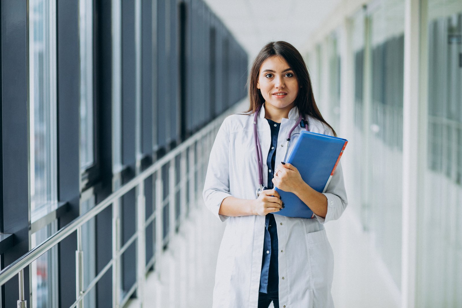 attractive female doctor standing with documents at the hospital